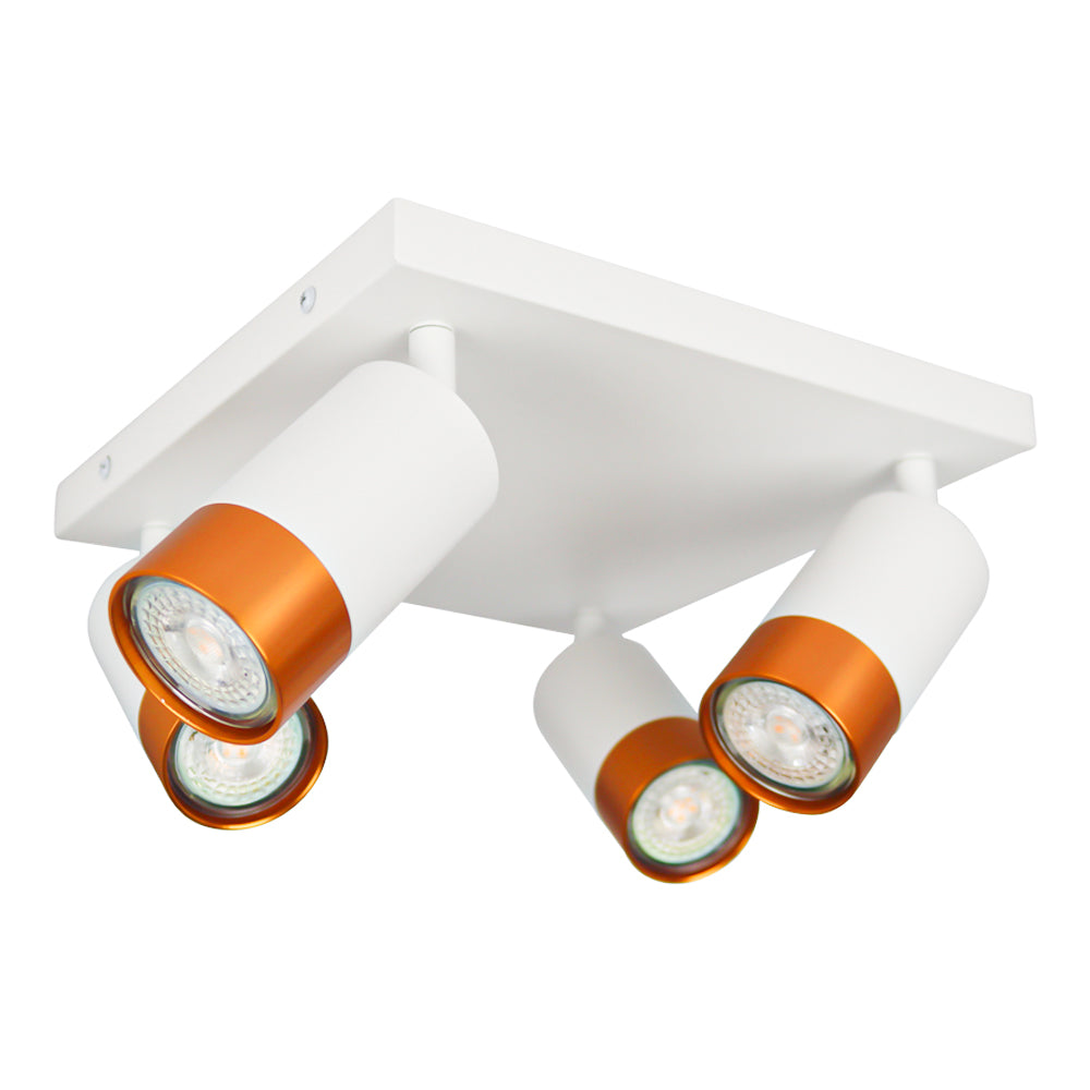 Quadratischer weißer Deckenstrahler mit vier drehbaren zylindrischen Lampen, mit kupferfarbenen Kanten versehen – schräge Unteransicht.