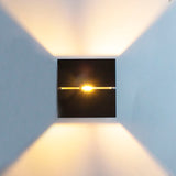 Schwarze, moderne Wandleuchte mit Auf- und Ablicht, Frontansicht mit warmer LED-Beleuchtung, die ein stimmungsvolles Lichtmuster an der Wand erzeugt.