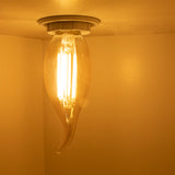 Dekorative Deckenleuchte mit einer warmweißen LED-Flammen-Filamentlampe in Tropfenform, von unten betrachtet in einem warm beleuchteten Raum.