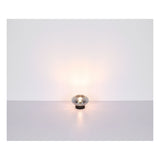 Chromglänzende Tischleuchte im modernen, kugelförmigen Design mit warmer Lichtverteilung, frontal fotografiert vor neutralem Hintergrund.