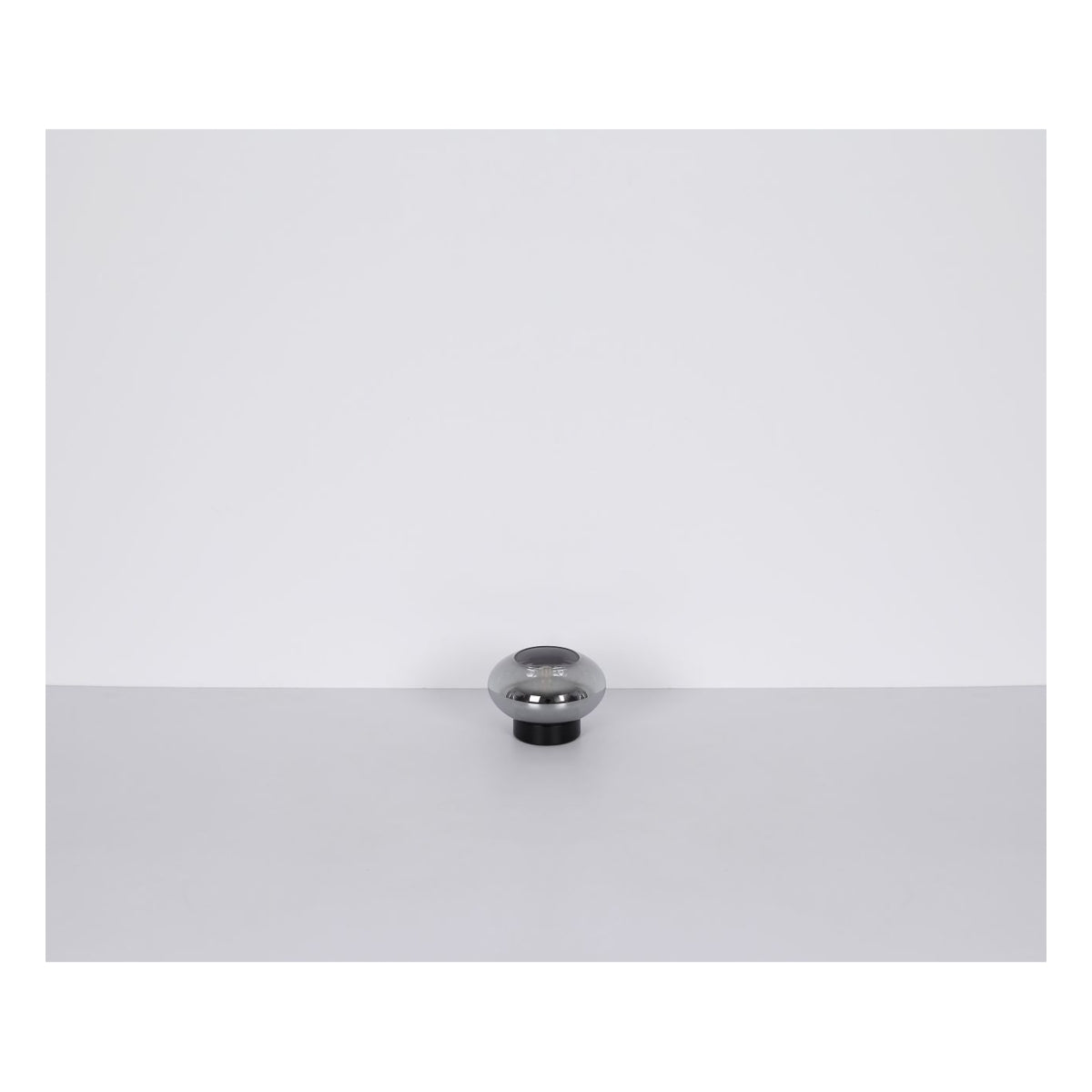Glänzender Möbelknopf aus Metall in runder Kugelform, von vorne vor neutralem Hintergrund fotografiert.