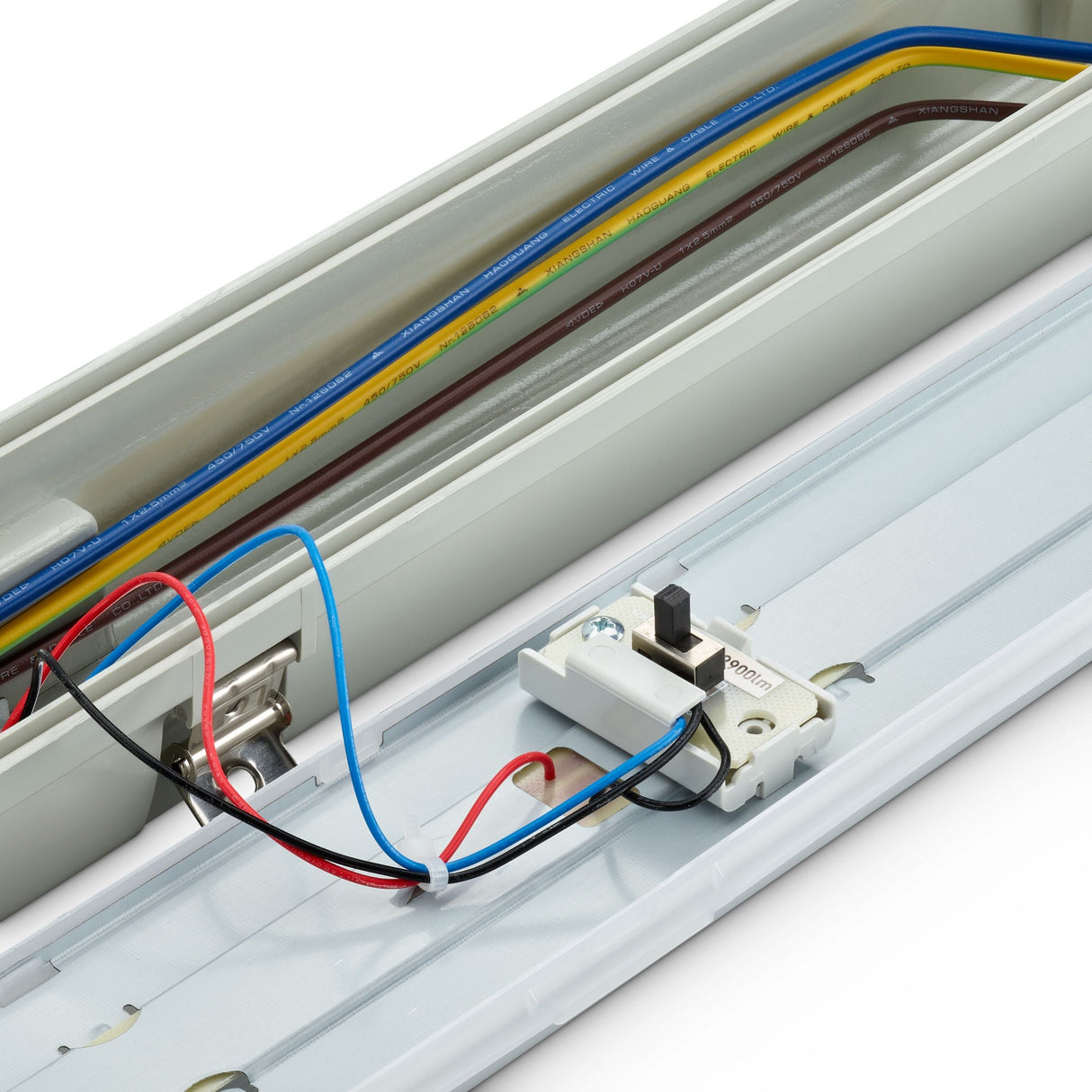 Nahaufnahme der Innenseite einer wasserdichten LED-TL-Leuchte von oben mit sichtbarer Verkabelung, Anschlüssen und einem Netzschalter, geeignet für die Installation in industriellen oder feuchten Umgebungen.