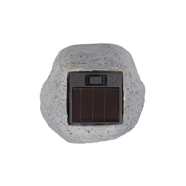 Frontansicht einer Gartenlampe in Form eines Kunststeins mit eingebautem Solarpanel und Ein-/Ausschalter.