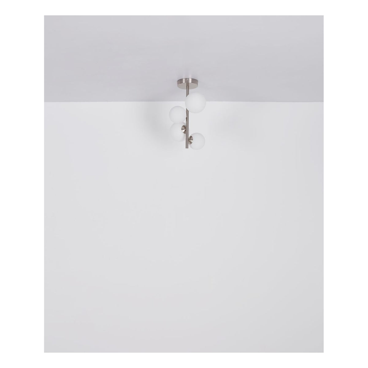 Moderne Deckenleuchte mit fünf Milchglaskugeln und einer Halterung aus gebürstetem Nickelmetall, von unten vor einem weißen Decken- und Wandhintergrund gesehen.