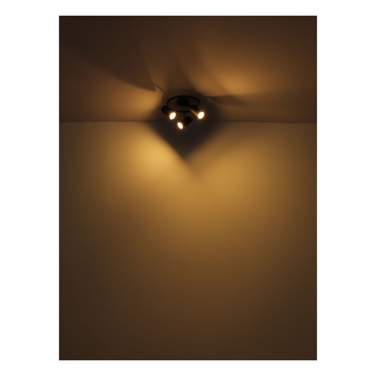 Deckenstrahler mit drei verstellbaren Lichtpunkten in warmer Beleuchtung, von unten an der Decke in einem dunklen Raum montiert.