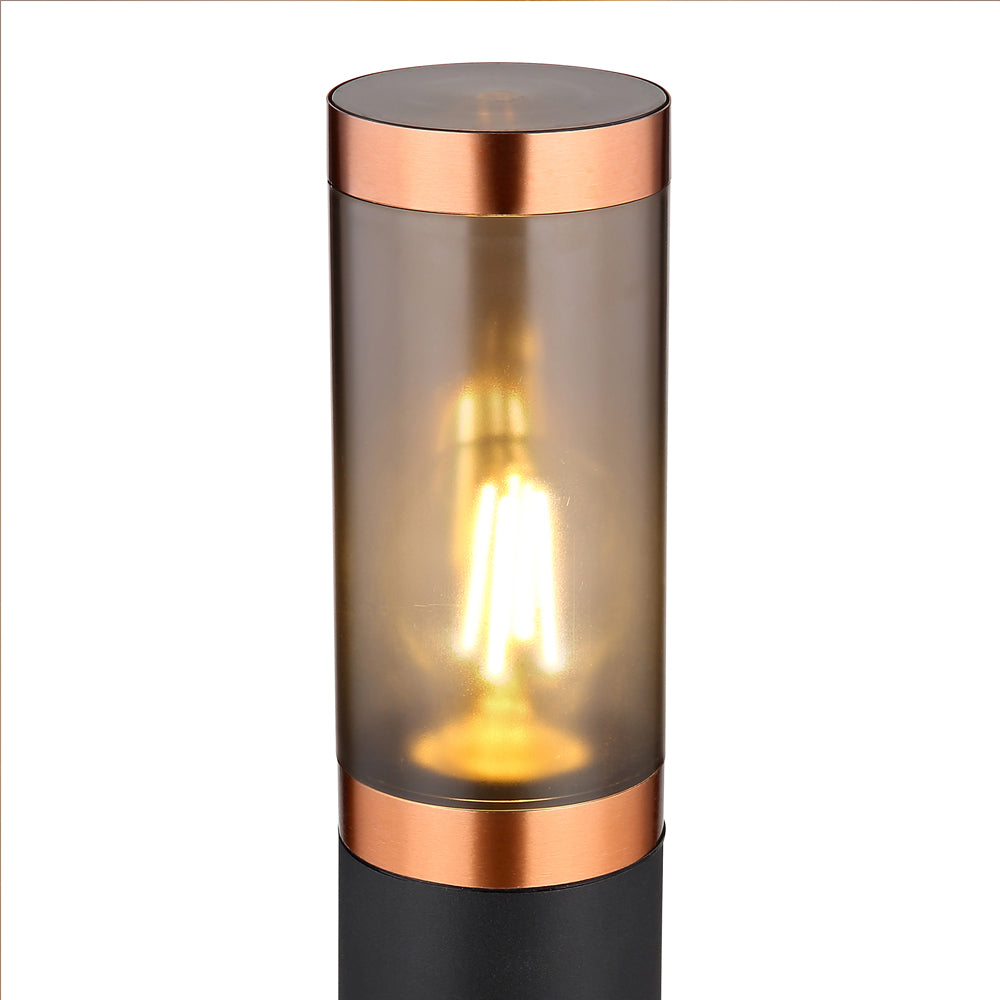 Moderne Außenleuchte im zylindrischen Design, mattschwarzem Sockel und kupferfarbenen Akzenten, ausgestattet mit einer warm leuchtenden LED-Filament-Glühbirne – Frontansicht.