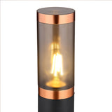 Moderne Außenleuchte im zylindrischen Design, mattschwarzem Sockel und kupferfarbenen Akzenten, ausgestattet mit einer warm leuchtenden LED-Filament-Glühbirne – Frontansicht.