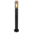 Stehende Außenleuchte in modernem Design, schwarzem Metallgehäuse und Kupferakzenten, mit sichtbarer Glühlampe hinter klarem Glas – Frontalansicht vor weißem Hintergrund.