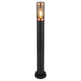 Stehende Außenleuchte in modernem Design, schwarzem Metallgehäuse und Kupferakzenten, mit sichtbarer Glühlampe hinter klarem Glas – Frontalansicht vor weißem Hintergrund.