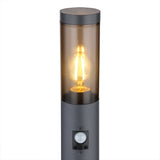 Außenstehleuchte mit Sensor und Retro-LED-Filamentbirne, Frontansicht, mit Rauchglasschirm und rundem schwarzem Gehäuse.