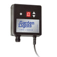 Vorderansicht des Garden Lights Timer + Sensor, ein schwarzes quadratisches Gerät mit digitaler Anzeige, Pfeiltasten und Anschlusspunkten für die Gartenbeleuchtung.