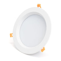 Runder weißer LED-Einbaustrahler mit matter Oberfläche und orangefarbenen Befestigungsclips, Schrägansicht.