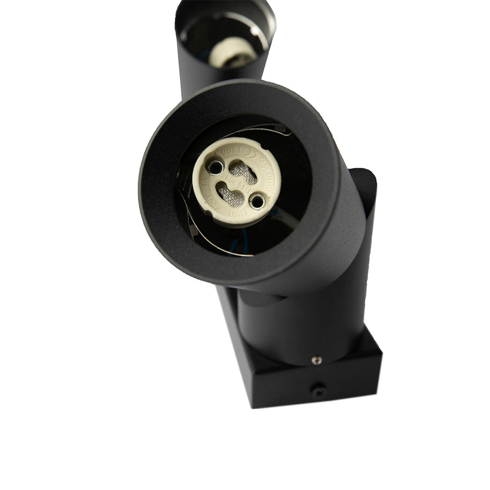 Schwarze doppelte GU10-Wandleuchte ohne Lichtquellen, Draufsicht auf offene Fassungen und zylindrisches modernes Design.