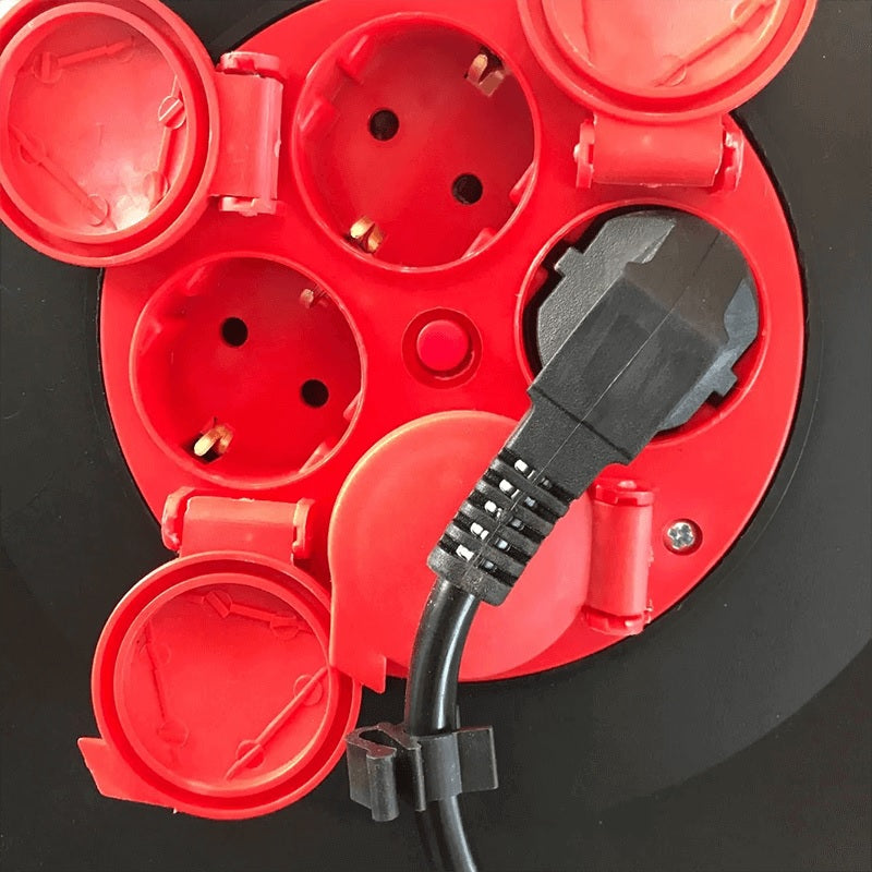 Nahaufnahme einer roten Kabeltrommel mit vier Schuko-Steckdosen, davon eine mit schwarzem Stecker in Betrieb, von oben fotografiert.