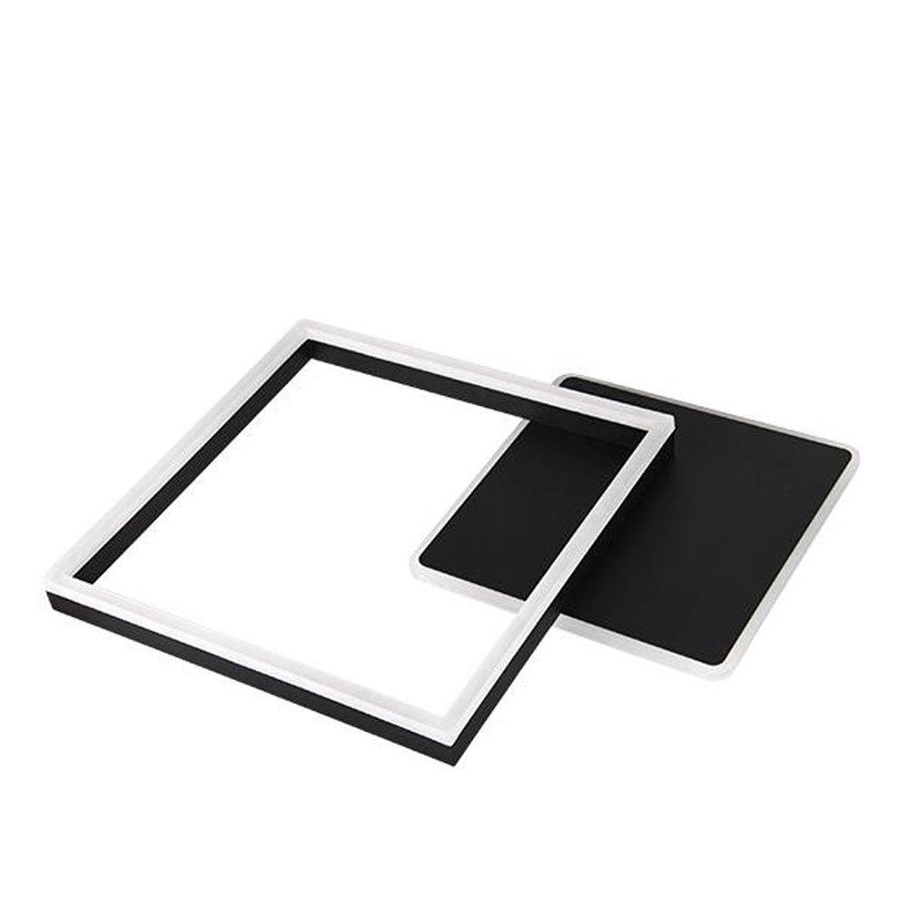 Moderne quadratische Wandleuchte im schwarz-weißen Design, von schräg oben betrachtet, mit minimalistischer offener Rahmenstruktur und integrierter LED-Beleuchtung.