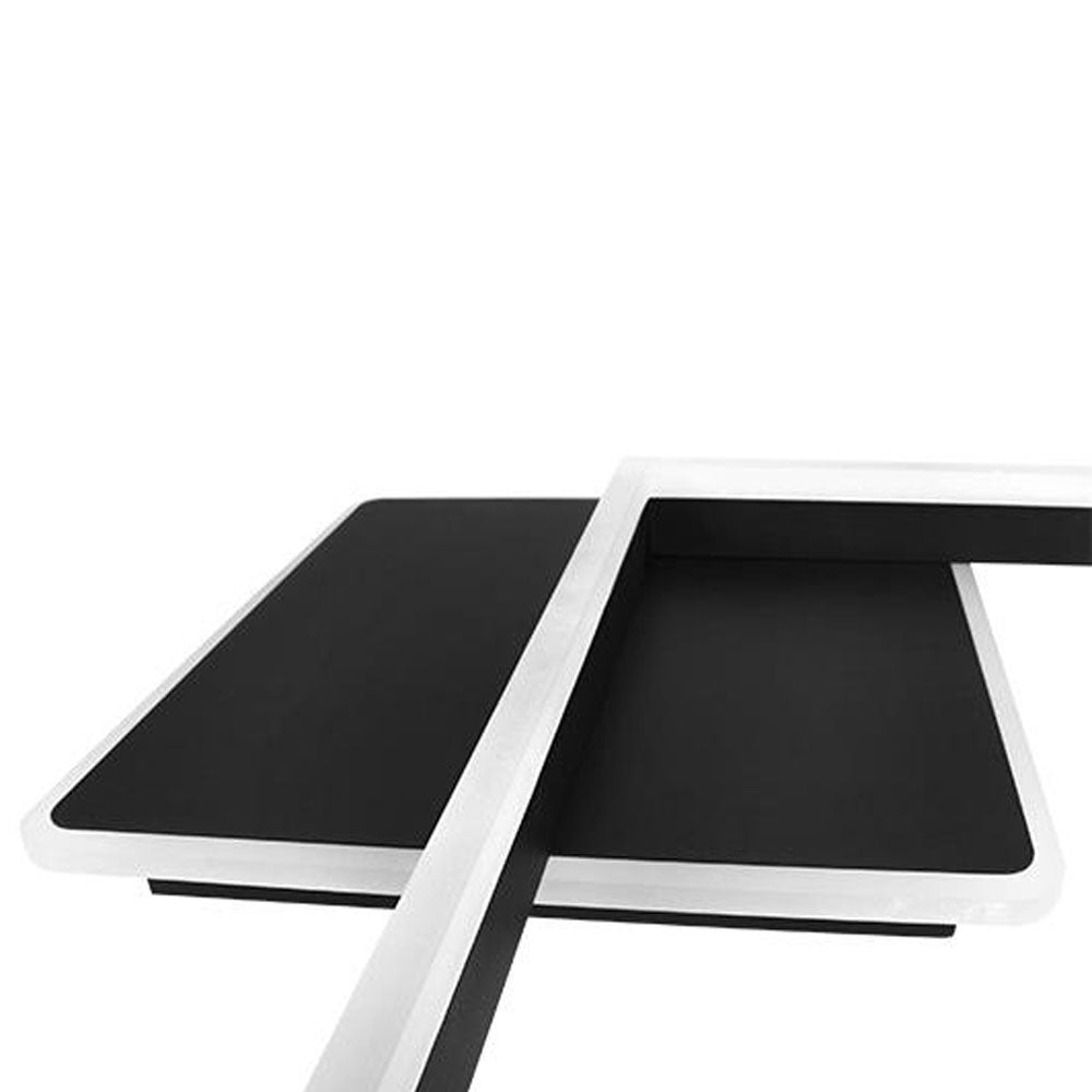 Nahaufnahme von oben auf einen modernen schwarzen L-förmigen Schreibtisch mit weiß umrandeten Kanten, minimalistisches Design.