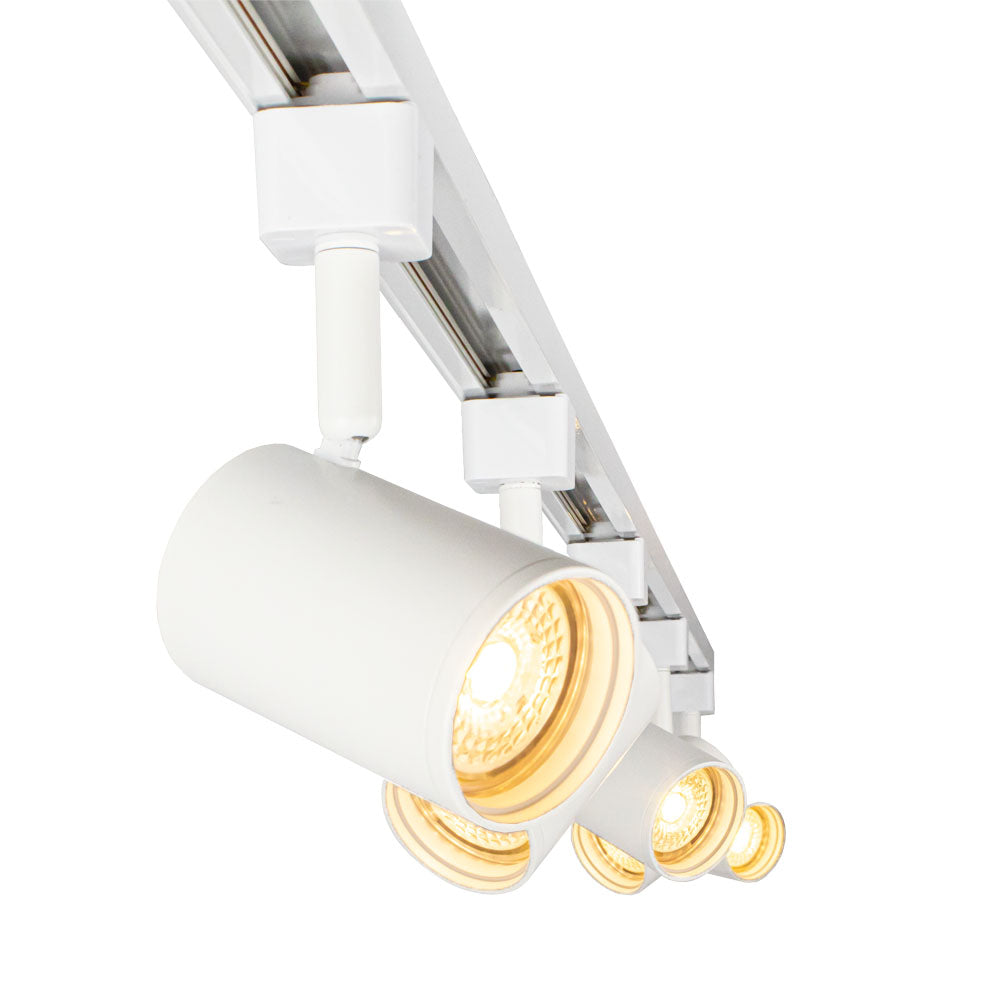 Weißer zylindrischer LED-Schienenstrahler an einem 3-Phasen-Schienensystem, von unten abgewinkelt mit mehreren Strahlern in Reihe, strahlend warmweißes Licht.
