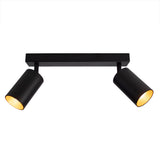 Schwarzer, moderner Deckenstrahler mit zwei nach vorne gerichteten, verstellbaren zylindrischen Lampen. Ideal für fokussierte Beleuchtung in Wohn- oder Arbeitsräumen.