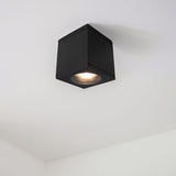 Schwarzer quadratischer Deckenstrahler mit integrierter LED-Beleuchtung, montiert an einer weißen Decke – Ansicht von unten.