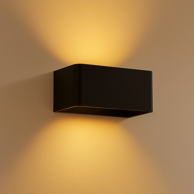 Moderne schwarze Wandleuchte mit Auf- und Ab-Licht, montiert an einer beigen Wand, aus schräger Seitenansicht.
