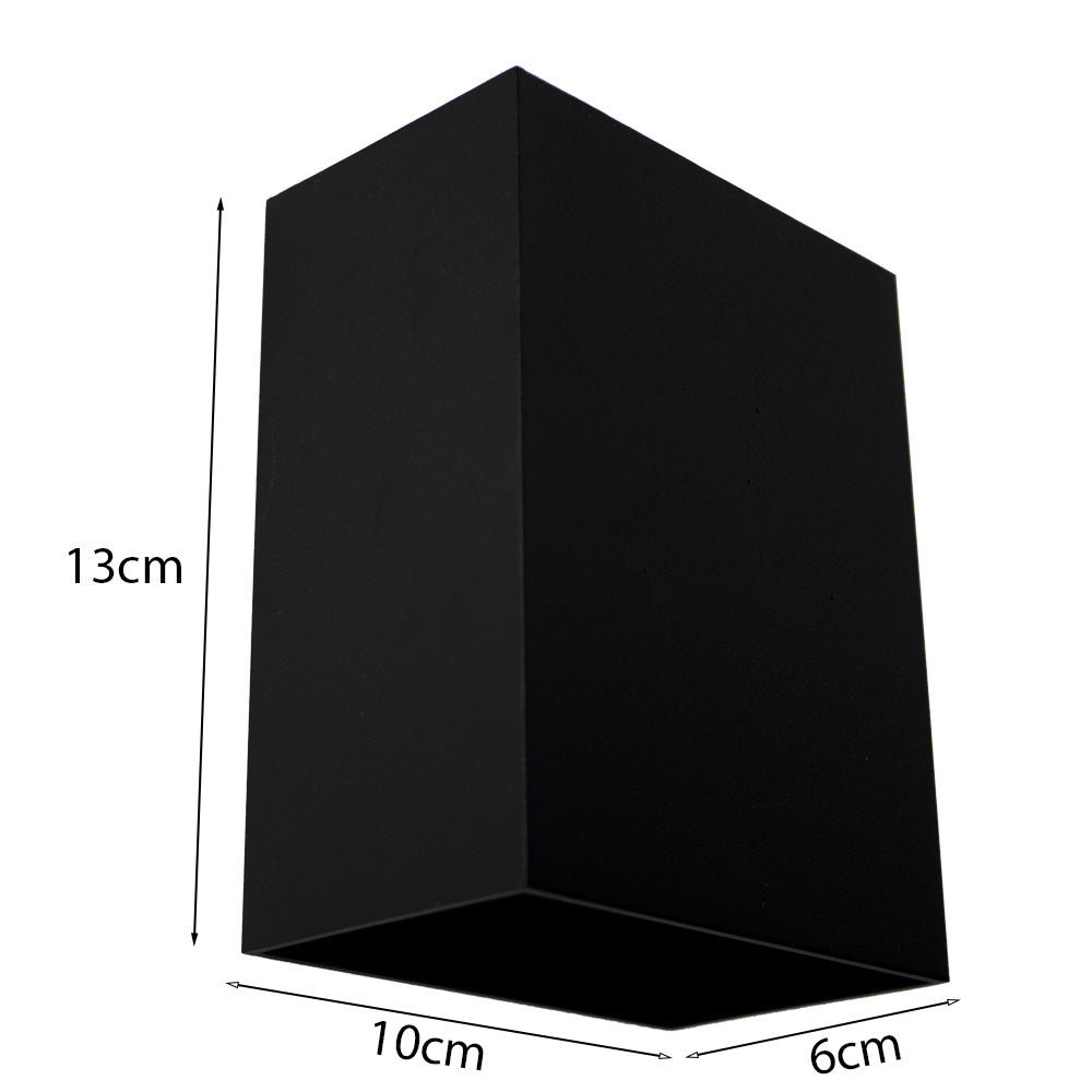 Schwarze rechteckige Wandleuchte mit den Maßen 13x10x6 cm, schräg vor weißem Hintergrund dargestellt.