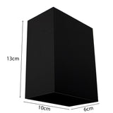 Schwarze rechteckige Wandleuchte mit den Maßen 13x10x6 cm, schräg vor weißem Hintergrund dargestellt.