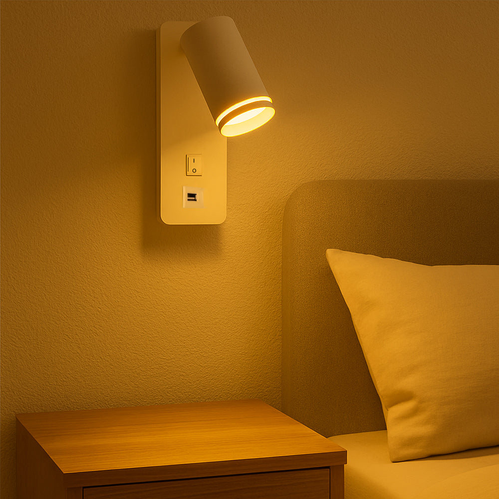 Moderne Wandleuchte mit USB-Anschluss und Schalter, neben einem Bett über einem Nachttisch montiert, aus der Perspektive fotografiert, in warmer Stimmungsbeleuchtung.