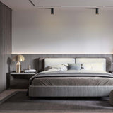 Luxuriöses, modernes Doppelbett in einem minimalistischen Schlafzimmer, Vorderansicht, mit gepolstertem Kopfteil, integrierter LED-Rückwandbeleuchtung und stilvollen Nachttischen mit Designerlampen.