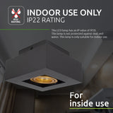 Schwarze quadratische LED-Deckenleuchte mit goldfarbenem Strahler, geeignet für den Innenbereich, schräg fotografiert in einem modernen Interieur-Ambiente, mit Schutzart IP22 für den Innenbereich.