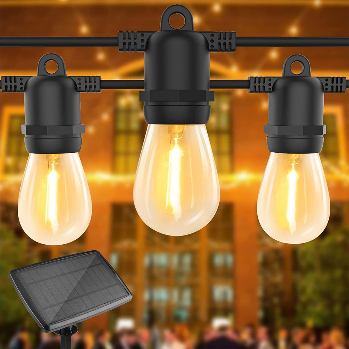 Nahaufnahme einer wasserdichten Solar-Außenleuchte mit Edison-LED-Birnen an einem schwarzen Kabel, inklusive Solarpanel – ideal für Garten-, Terrassen- oder Partybeleuchtung.