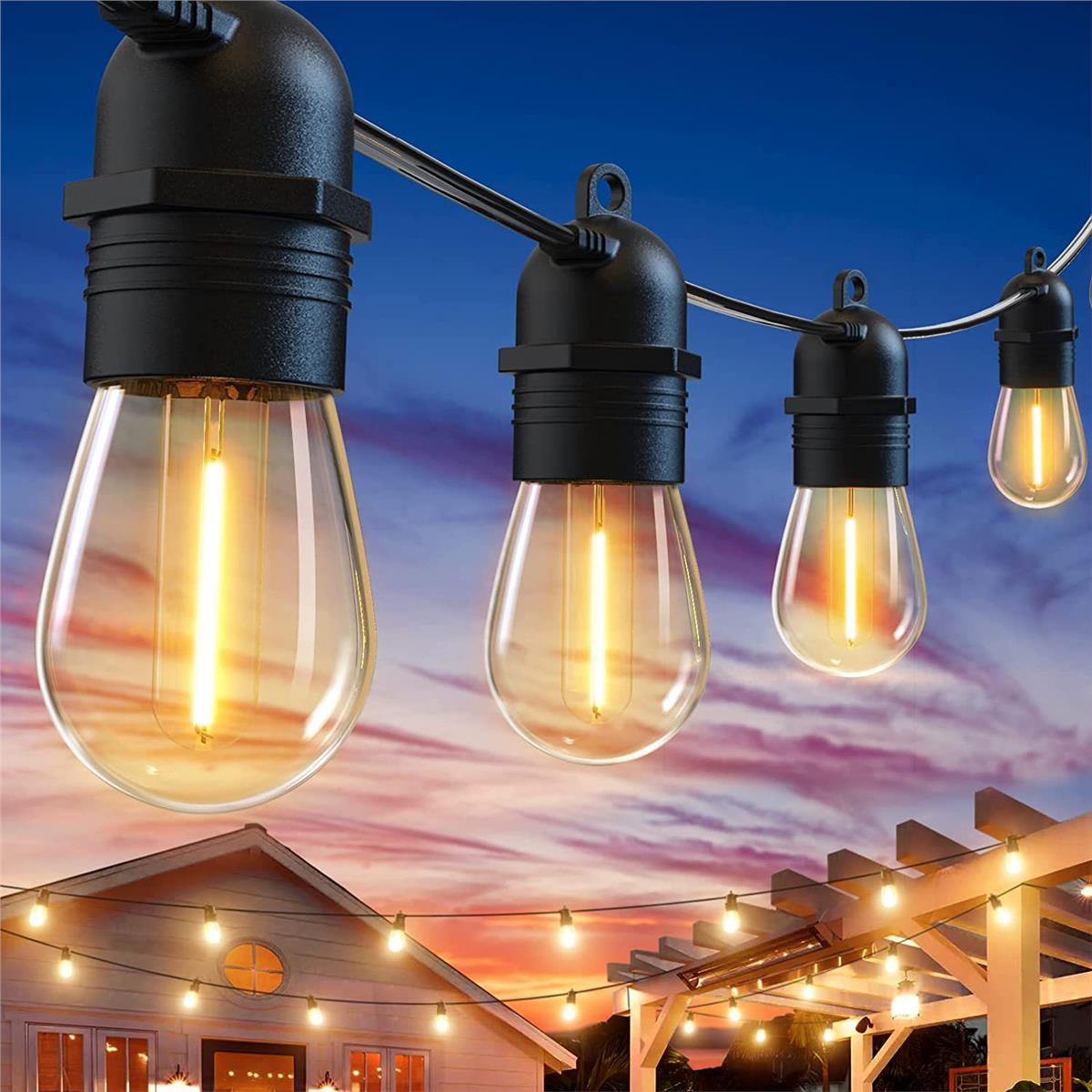 Nahaufnahme von wasserdichten LED-Partylichtern für den Außenbereich mit warmem Schein, die über einer Terrasse und einem Garten hängen und einen Blick auf ein Haus bei Sonnenuntergang bieten.