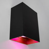 Mattschwarze, moderne Wandleuchte mit rechteckigem Design und rosa Beleuchtung unten, Seitenansicht auf einer weißen Wand.