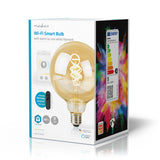 Produktverpackung der Nedis Wi-Fi Smart Bulb mit warm- bis kaltweißem Glühfaden, schräge Vorderansicht der Box mit der intelligenten Lichtquelle, Spezifikationen wie E27-Fassung, 380 Lumen und Kompatibilität mit Alexa und Google Assistant.