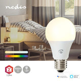 Nahaufnahme der intelligenten LED-Glühbirne (E27, 9 W, 806 Lumen) von Nedis mit ZigBee-Unterstützung, geeignet für Google Assistant und Amazon Alexa, platziert vor einem stimmungsvollen Schlafzimmerinterieur.