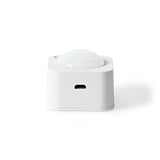 Weißer Nedis SmartLife PIR-Bewegungssensor, Vorderansicht mit Blick auf den USB-Ladeanschluss und einer halbkugelförmigen Sensorlinse oben.