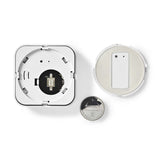 Draufsicht eines geöffneten Nedis Smart Mini Tür- und Fenstersensors, einschließlich des Inneren mit elektronischen Komponenten und der mitgelieferten CR2032-Lithium-Knopfzellenbatterie.